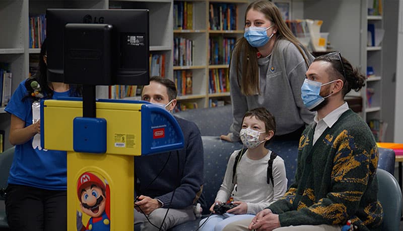 Hospitalized child playing on Starlight Gaming Station in hospital playroom. 