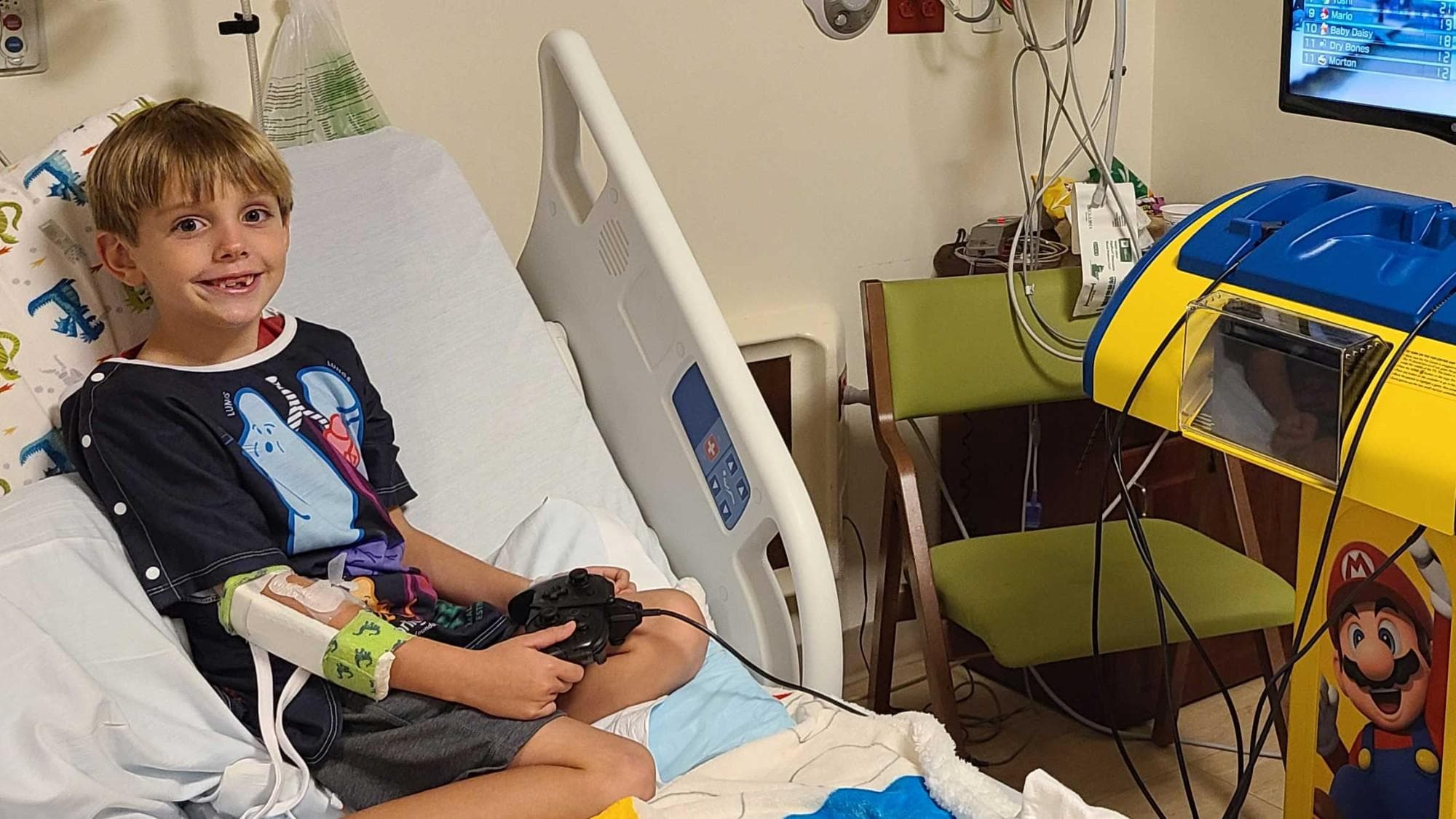 Hospitalized child playing on the Starlight Nintendo Switch Gaming Station while sitting in hospital bed.