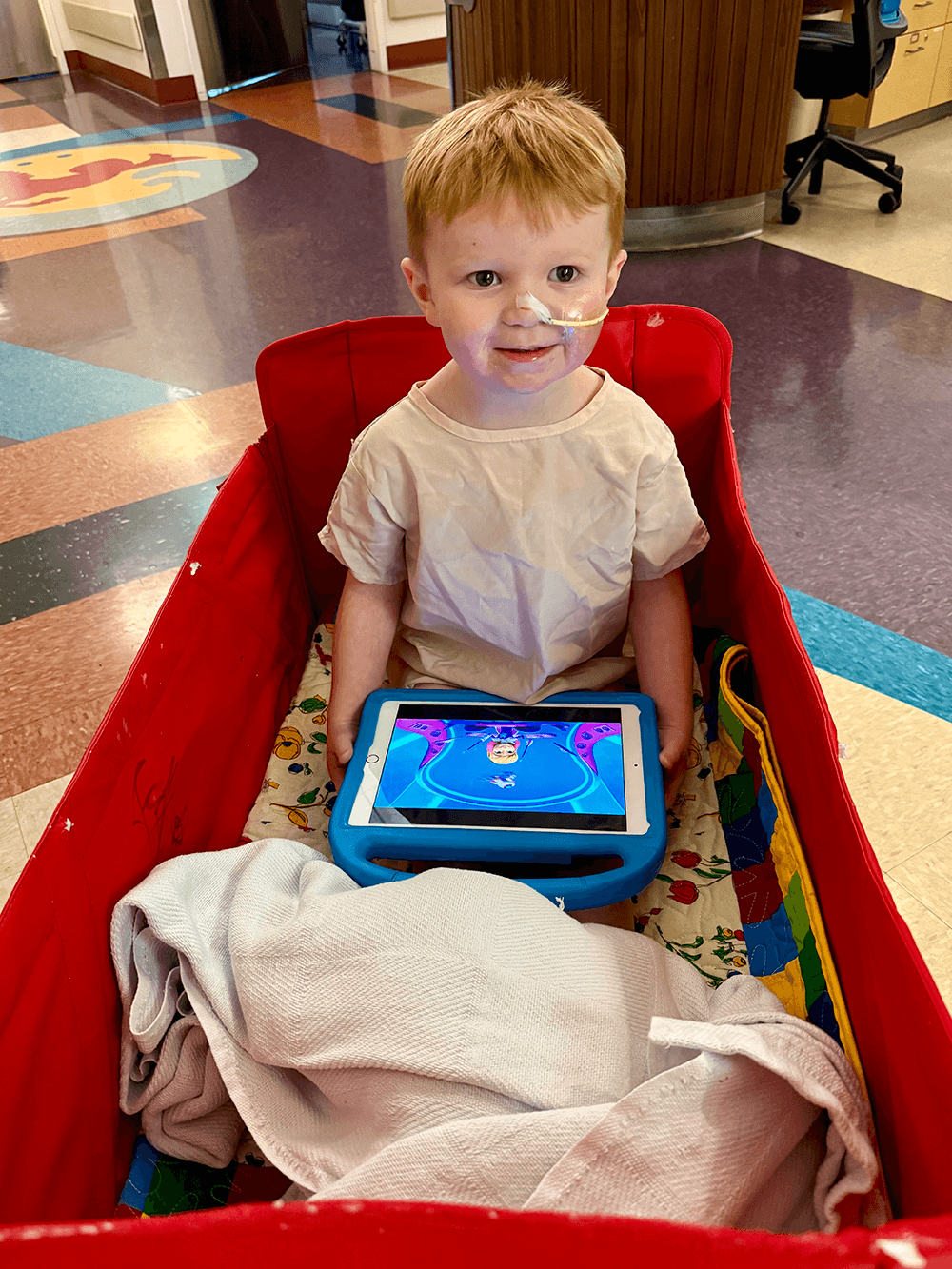 hospitalized boy, sitting and playing in Starlight Hero Wagon